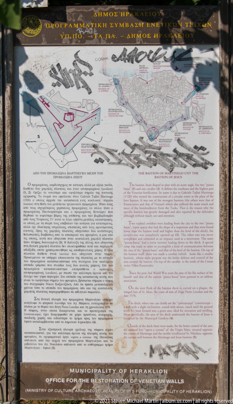 Outdoor interpretive panel with map, aerial views, diagrams, and Greek-English text about Heraklion's Venetian fortifications.