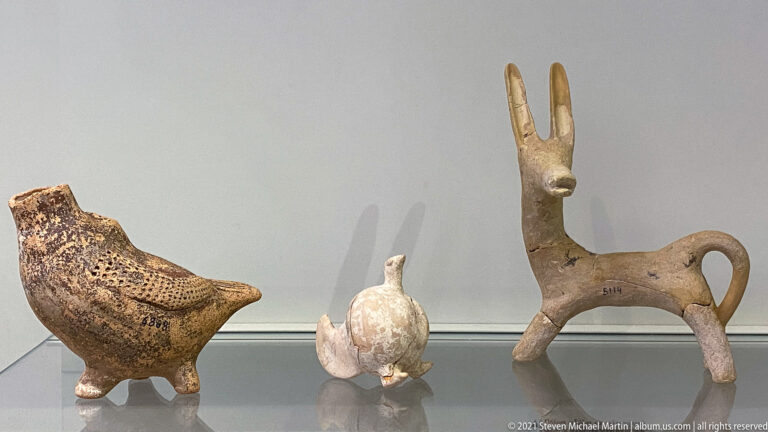 Three small terracotta animal vessels: two bird-like forms and a long-eared quadruped with a loop handle.