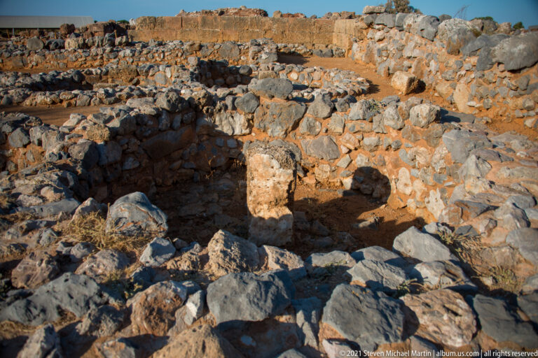 Small stone-lined enclosure with an upright rectangular block among rough rubble masonry.