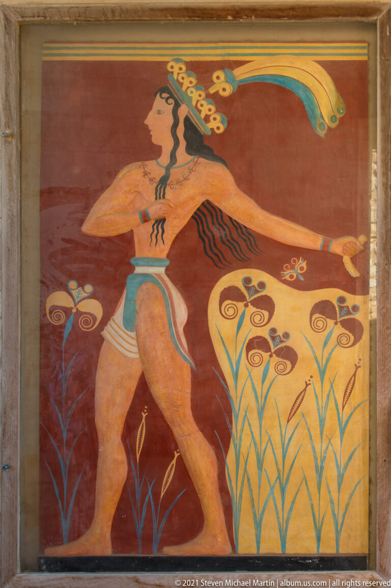 Reconstructed Prince of the Lilies fresco showing a striding male figure with feathered headdress among stylized plants.