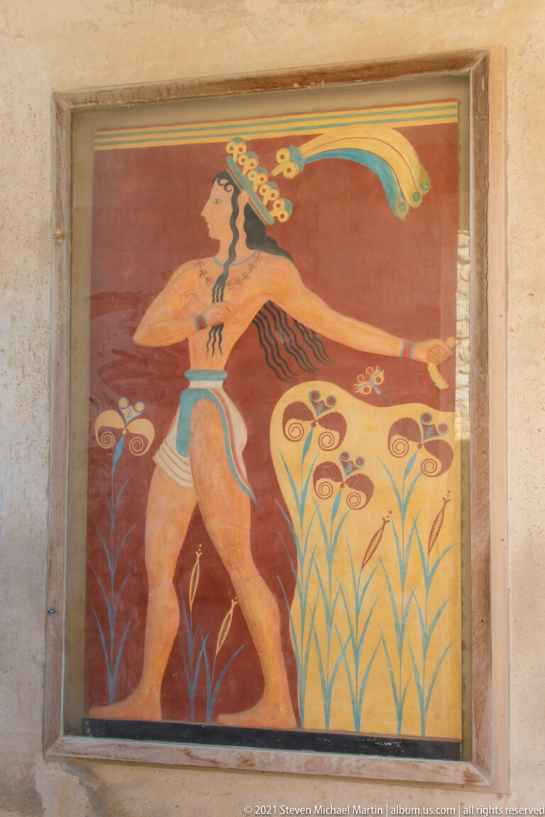 Prince of the Lilies fresco reconstruction displayed inside a pale recessed architectural frame at Knossos.