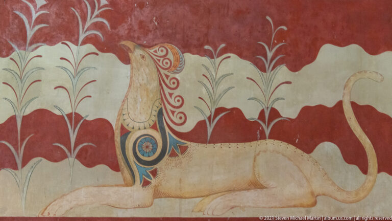 Reconstructed griffin fresco with patterned wing, curled tail, and stylized plants on a red-and-cream wall.