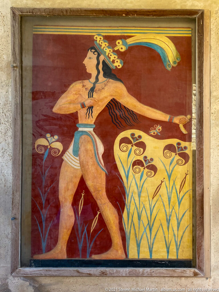 Frontal view of the Prince of the Lilies fresco reconstruction with striding figure, headdress, and stylized flowers.