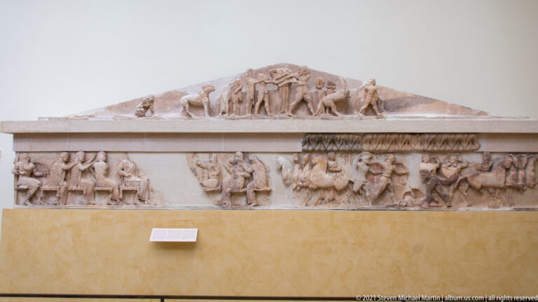 Reconstructed museum display of a triangular pediment and long sculpted frieze from the Siphnian Treasury at Delphi.