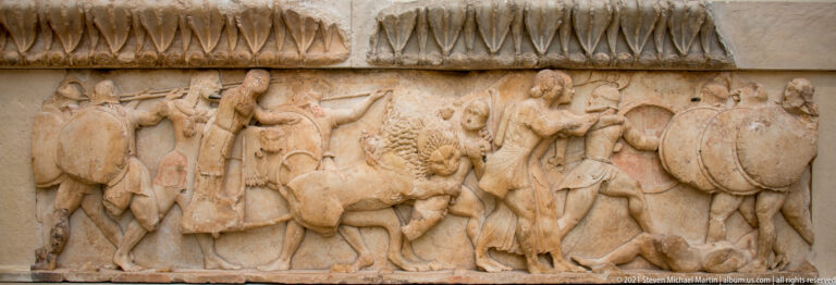 Long Archaic marble frieze with armed figures, overlapping shields, and a lion attacking during the Gigantomachy.