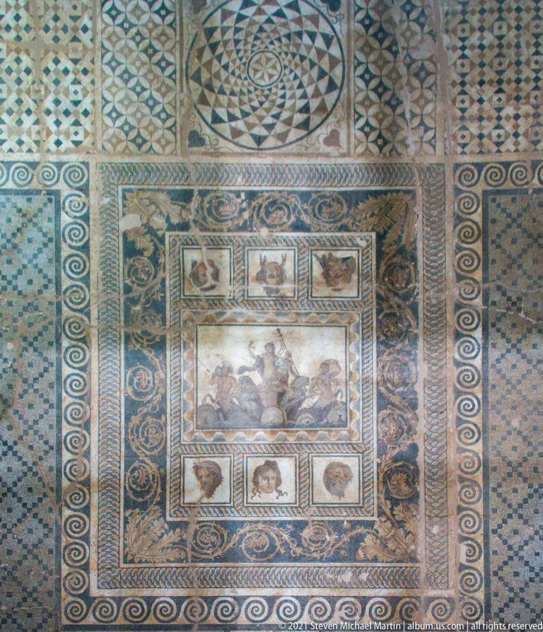 Wide view of the complete Mosaic of the Epiphany of Dionysus, surrounded by theatrical masks, portrait panels, and geometric ornament.
