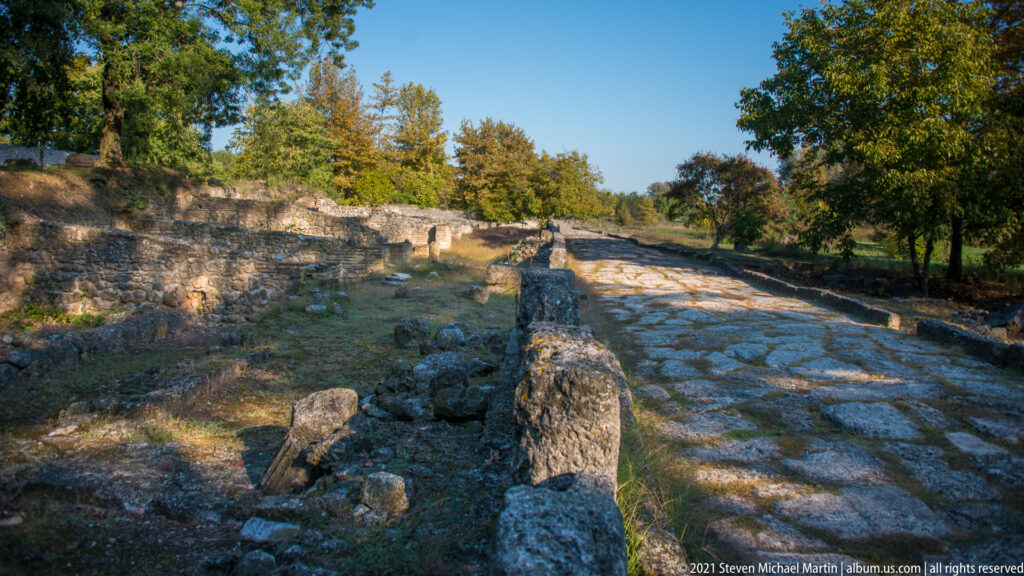 Broad stone-paved street running through the excavated fortified city of ancient Dion.