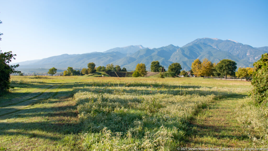 Open meadow in the Archaeological Park of Dion with Mount Olympus visible on the horizon.