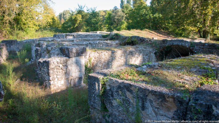Thick stone walls forming several deep adjoining rooms or compartments in the archaeological site at Dion.