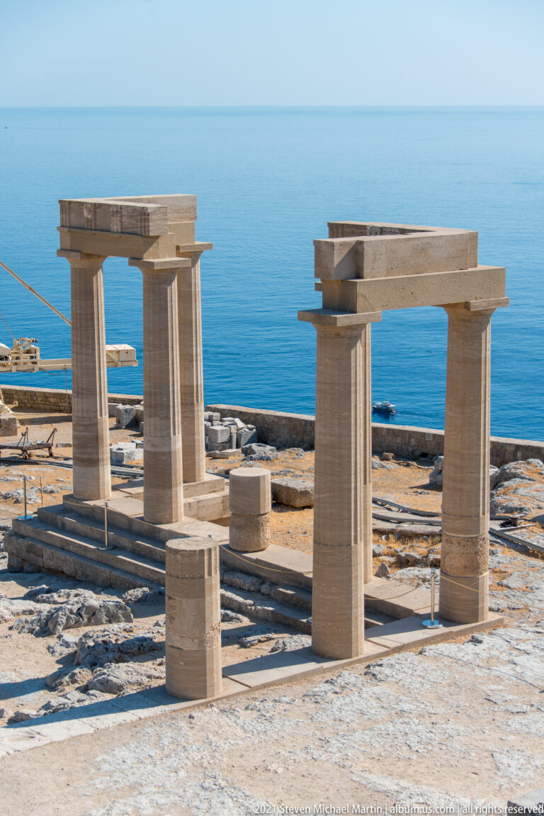 Restored columns and lintels of the Temple of Athena Lindia stand on the summit terrace above the Aegean Sea.