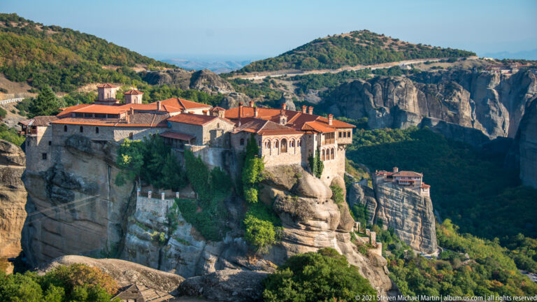 Large monastery occupies a foreground rock summit, with a smaller monastery on another pillar to the right.