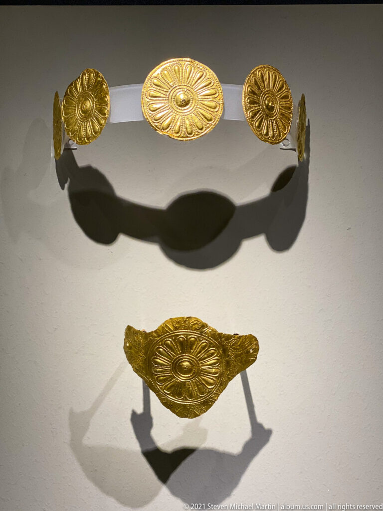 Curved set of embossed gold rosette fittings with a separate matching ornament displayed below.