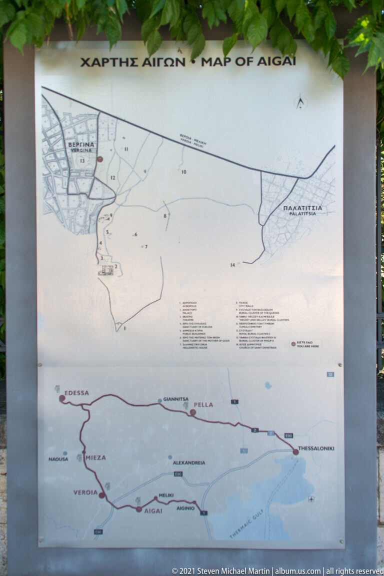 Mounted orientation board with a detailed Aigai site plan above a regional road map.