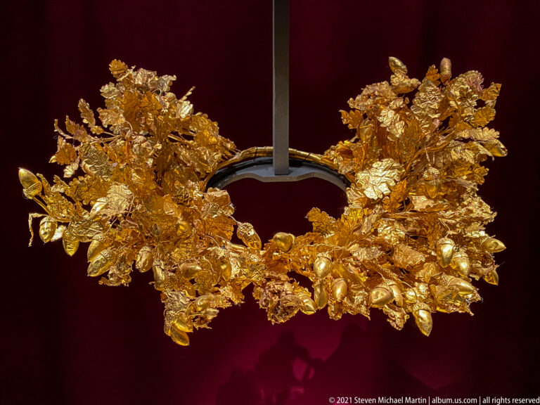 Full view of Philip II’s large gold oak wreath, with dense hammered leaves and acorns forming an open circular crown.