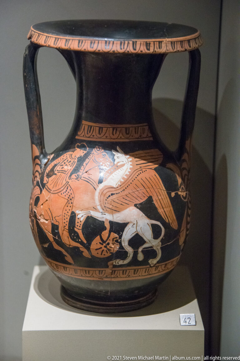 Black-glazed two-handled red-figure vessel decorated with a horse, human figures, white highlights, and patterned borders.