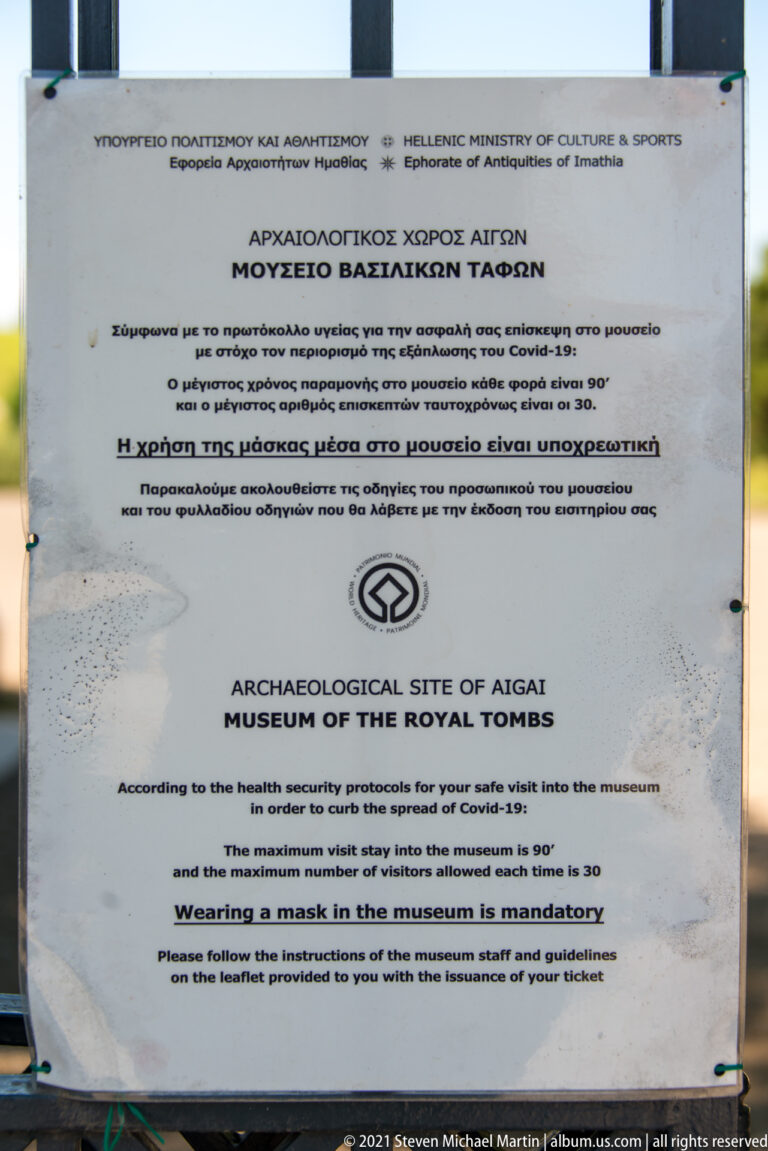 Bilingual COVID-19 visitor notice for the Archaeological Site of Aigai and Museum of the Royal Tombs.