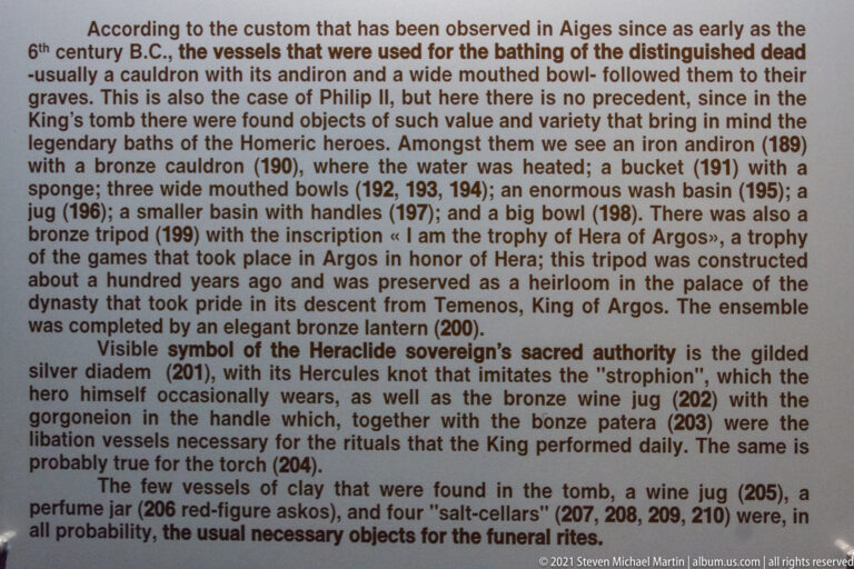 English museum panel describing vessels, weapons, and other grave goods recovered from the Tomb of Philip II.