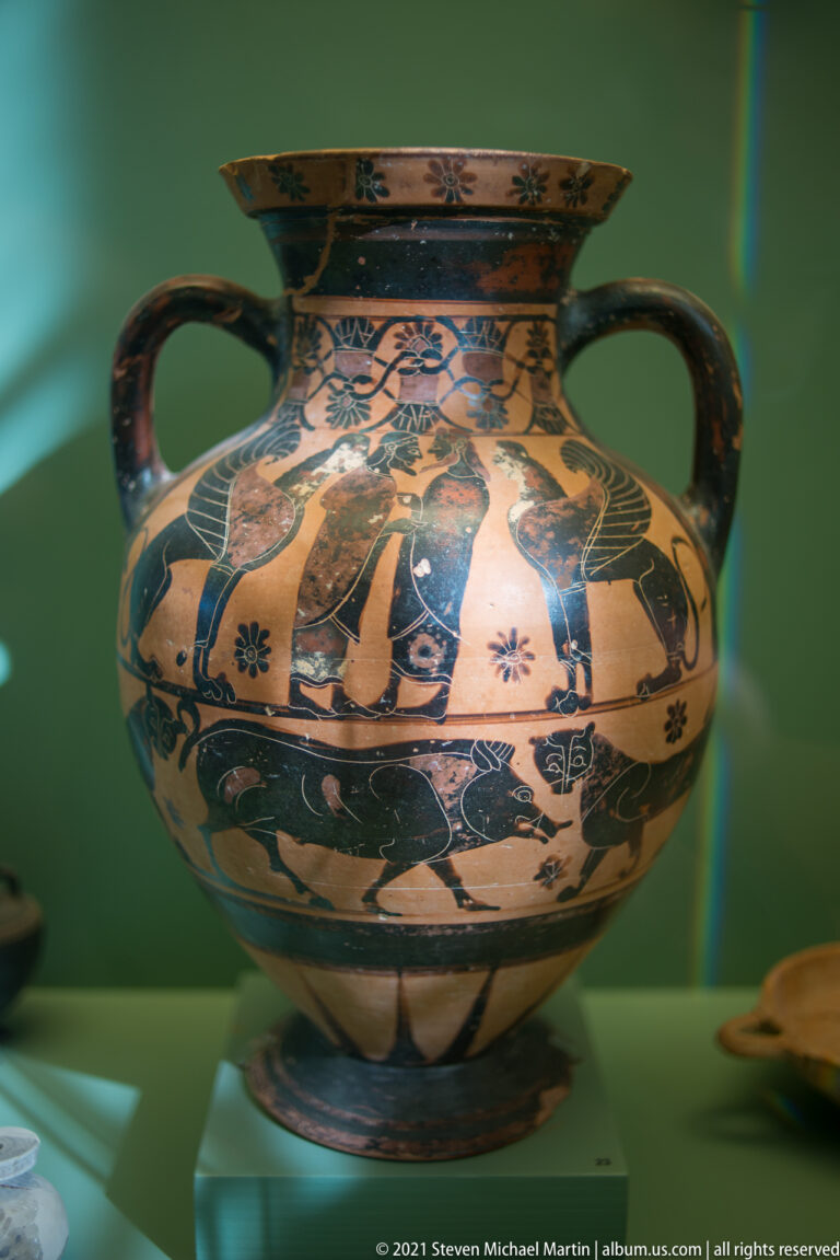 Large two-handled ceramic vessel with a black-figure human frieze, animal and vegetal ornament, and a flaring rim.