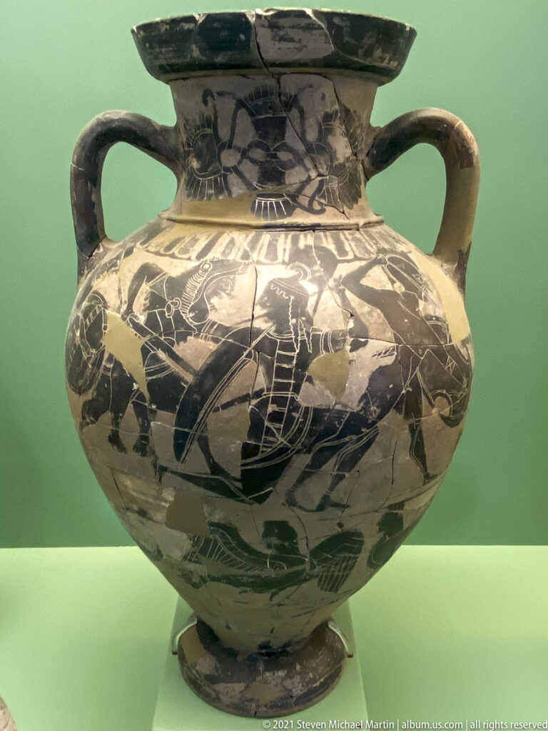 Large restored two-handled black-figure vessel with animal and human friezes across its rounded body.