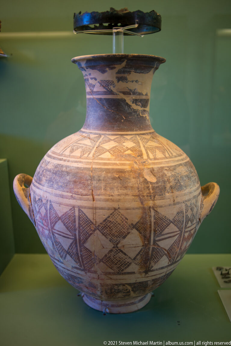 Large two-handled ceramic vessel with a wide rim and dense geometric painted decoration across its rounded body.