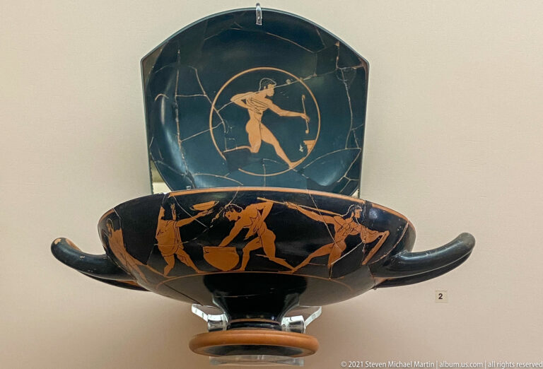 Two red-figure drinking cups with long handles, one showing an exterior frieze and the other a central interior figure.