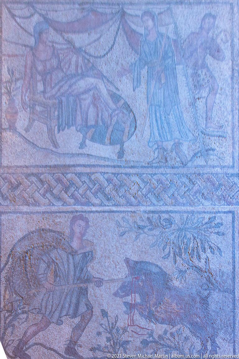 Large ancient mosaic pavement with several figurative scenes arranged in horizontal registers and framed by geometric borders.