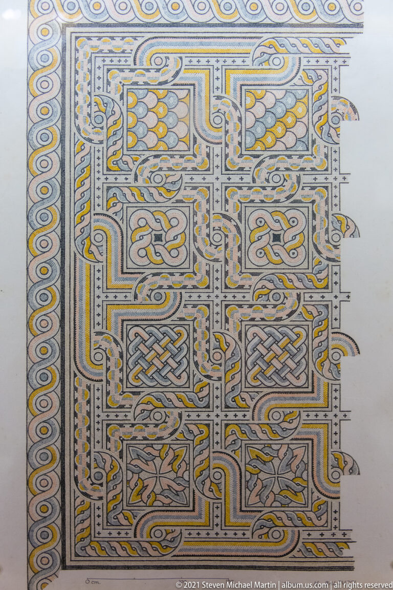 Complex polychrome mosaic with nested rectangular panels, braided borders, scrolls, and interlaced geometric knots.