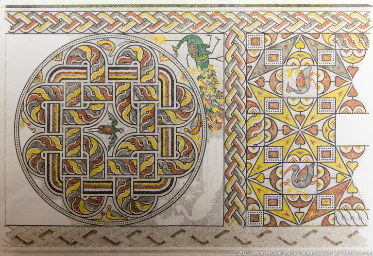 Decorative mosaic with a large circular interlace medallion beside star patterns, braided borders, floral motifs, and a small bird.