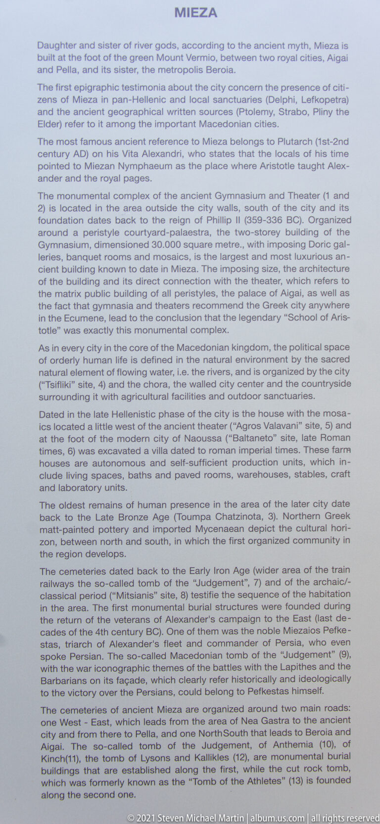 Close view of a pale information panel headed “MIEZA,” filled with dense English historical and archaeological text.