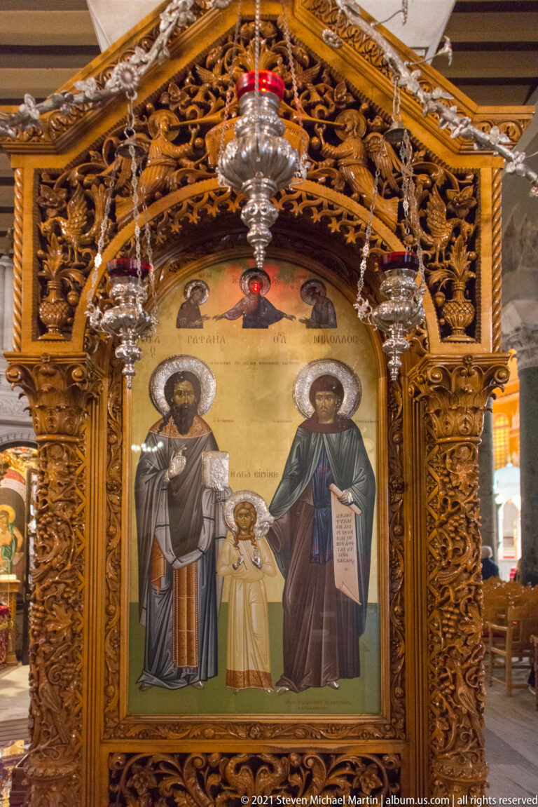 Orthodox icon of two haloed saints and the Christ Child in an ornate gilded carved frame.