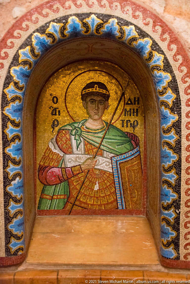 Gold-ground mosaic of Saint Demetrios in an arched niche with decorative border.