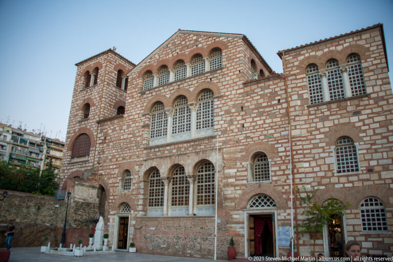 Brick-and-stone exterior of the Church of Saint Demetrios with rows of arched windows.