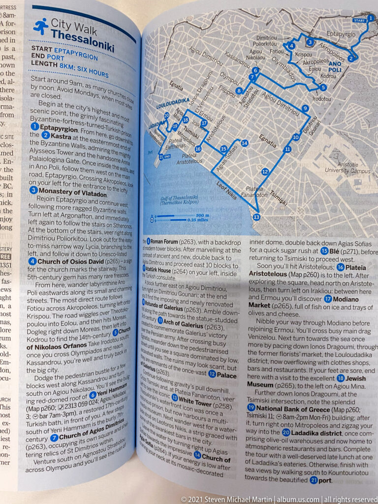 Open travel guide with a Thessaloniki street map, blue route markings, and sightseeing text.