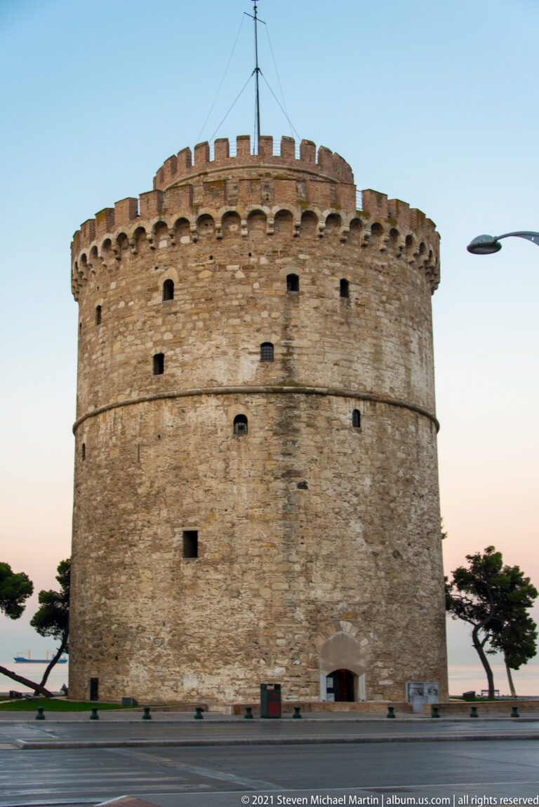 Full exterior of the White Tower at dusk, framed by trees and streetlights.