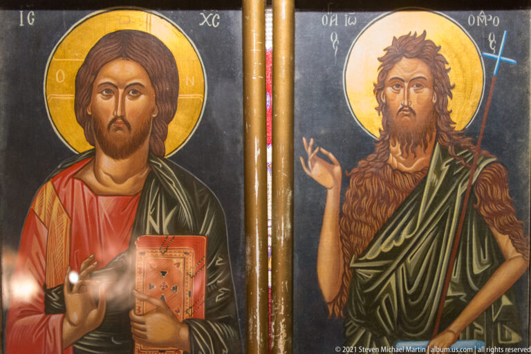 Paired Orthodox icons of Christ with a Gospel book and Saint John the Baptist holding a staff.