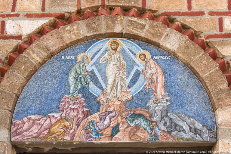 Close view of Transfiguration mosaic showing Christ in white, blue mandorla, flanking saints, and disciples below.