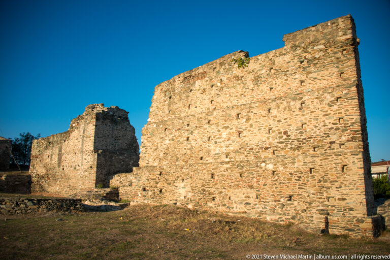 Long rough-stone fortress wall with projecting masonry blocks inside Thessaloniki's Heptapyrgion precinct.