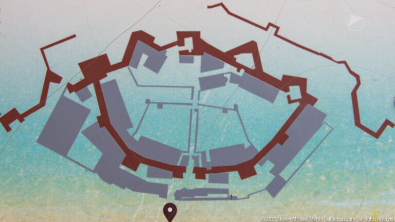 Plan diagram with thick red fortification lines and gray internal blocks showing the Heptapyrgion complex.