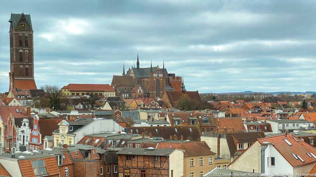 Elevated Wismar skyline with red roofs, St. Mary's tower at left, and St. George's Church near center.