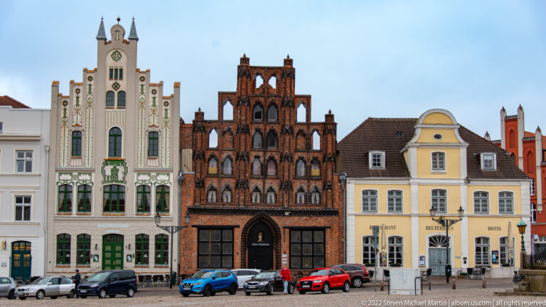 Historic gabled houses in Wismar’s market square, including an ornate dark-brick stepped façade.