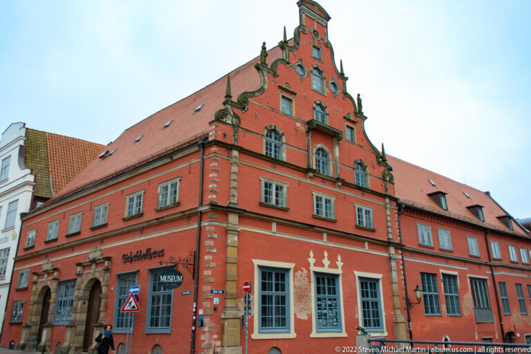 Red Schabbellhaus museum with ornate stepped-curved gable, pale window trim, and steep red-tiled roof.