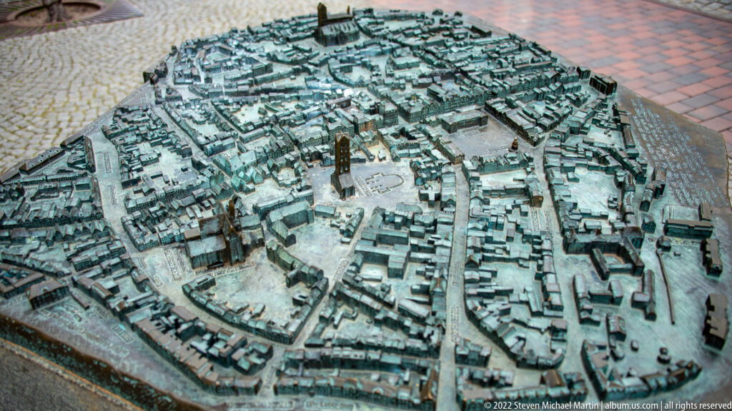 Oblique overhead view of a metal tactile model showing Wismar’s dense streets, buildings, and prominent church structures.