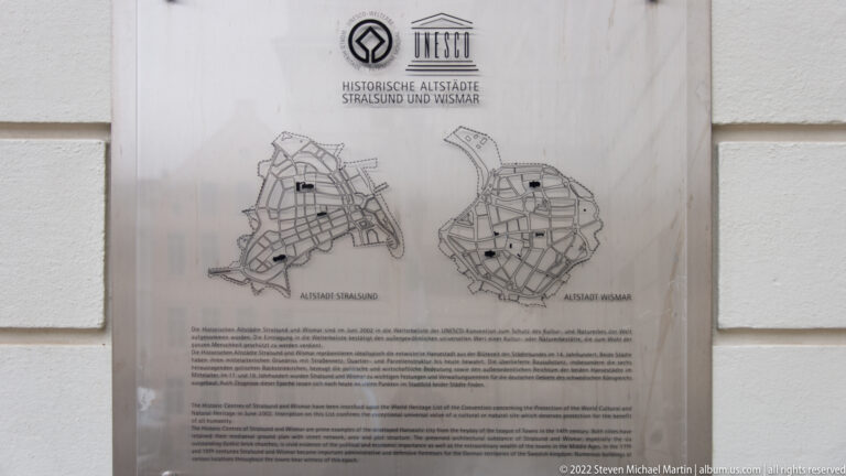 UNESCO heritage plaque with maps of Stralsund and Wismar and bilingual explanatory text.