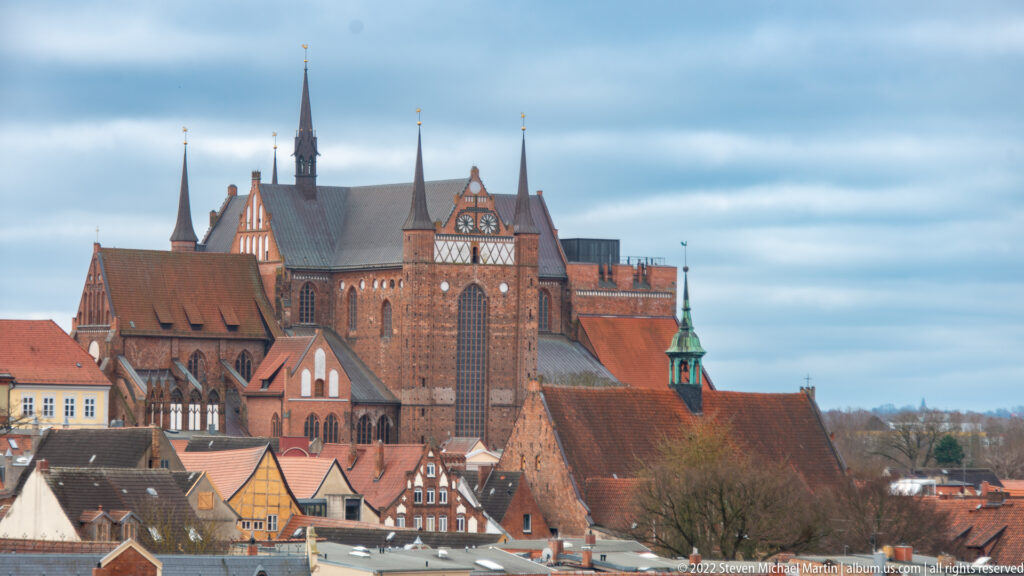 Elevated view of St. George's Church rising above red-tiled roofs and historic houses in Wismar.