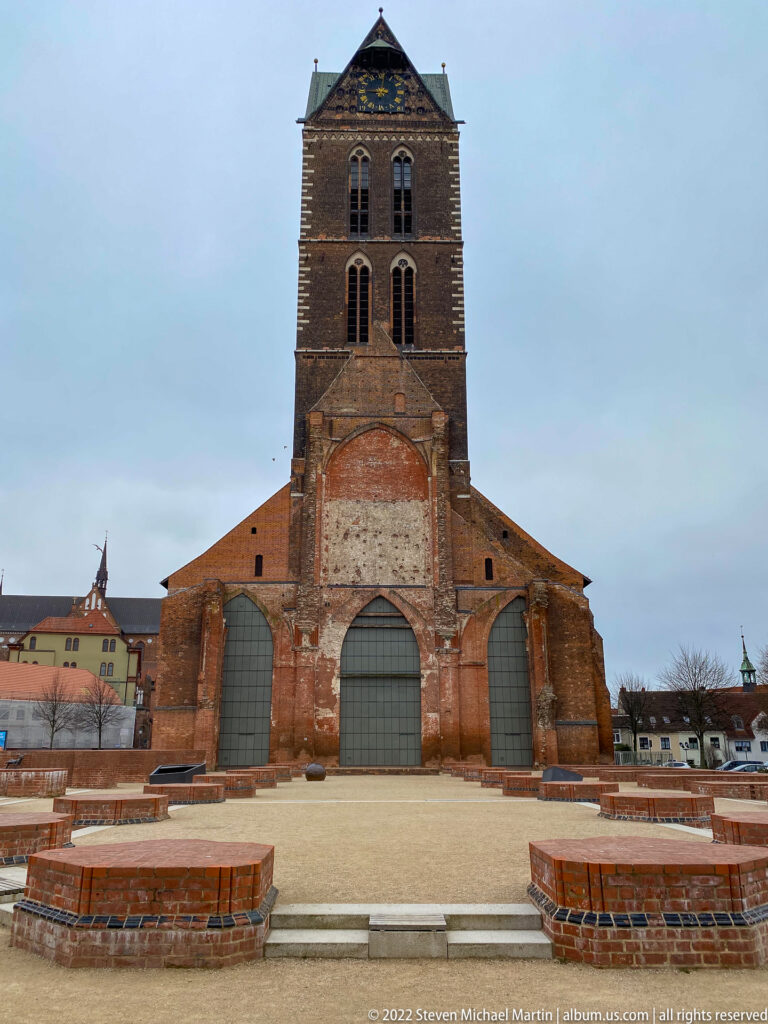 Surviving brick tower of St. Mary's Church behind low reconstructed foundation walls marking the demolished nave.
