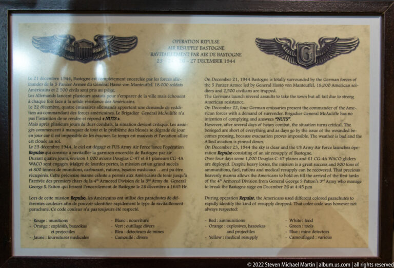 Interpretive panel titled “Operation Repulse” with bilingual text about the air resupply of Bastogne and wing emblems.