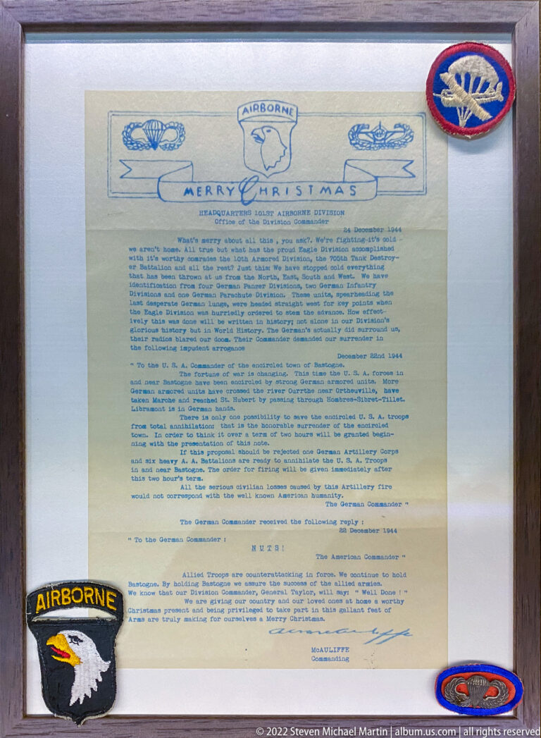 Framed wartime Christmas message headed “Merry Christmas” with airborne insignia arranged around the document.