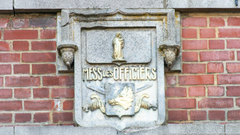 Carved stone plaque reading MESS DES OFFICIERS with small relief figures and military motifs.