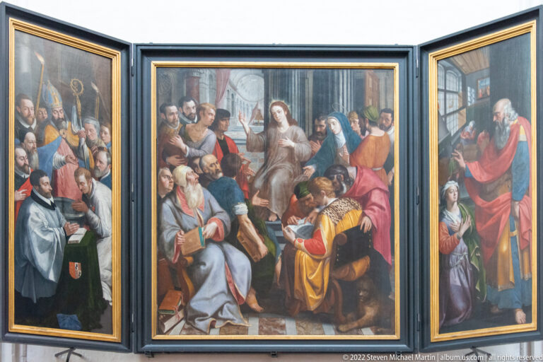 Open triptych of Christ among the Scribes, with the young Christ seated among scholars and listeners in richly colored robes.
