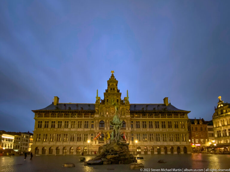 Evening view across Grote Markt with Antwerp City Hall behind the Brabo Fountain and illuminated surrounding façades.